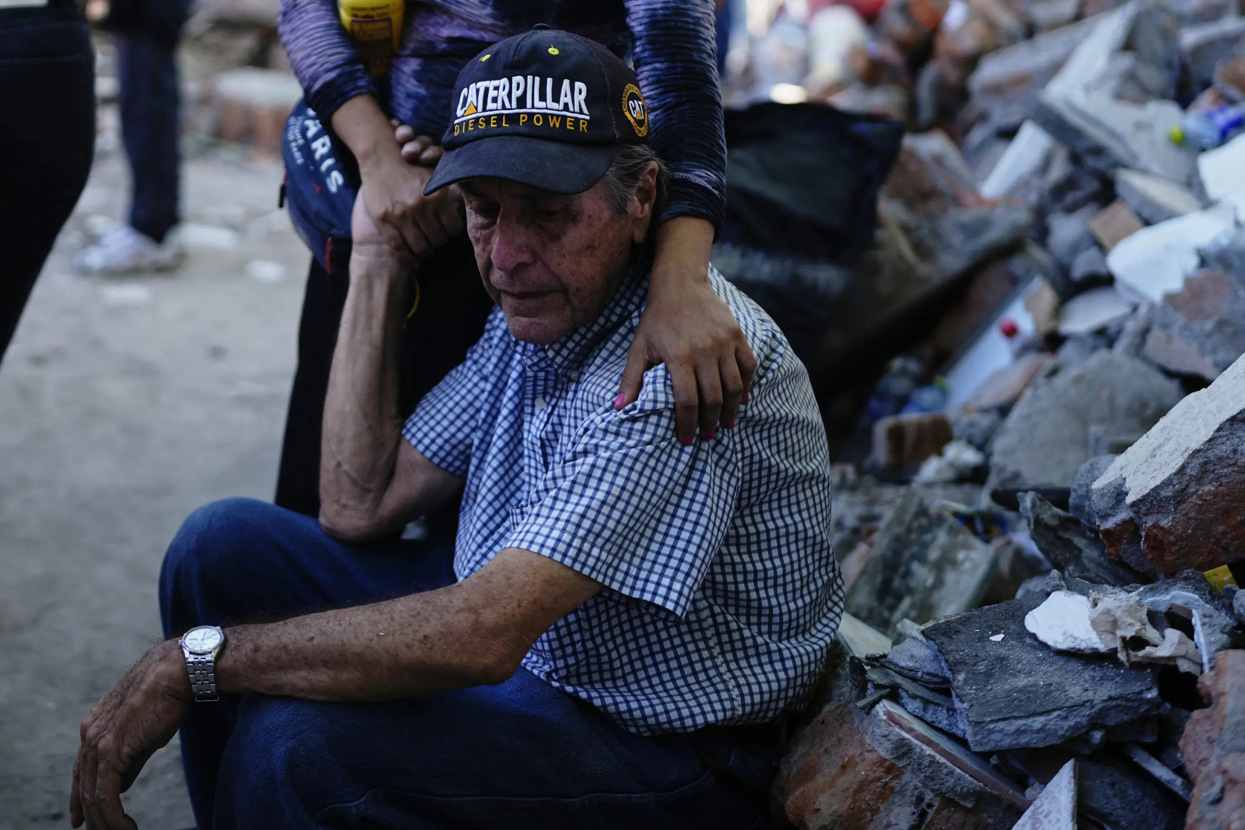 Un vecino espera mientras los equipos de rescate registran los escombros de su bloque de pisos derrumbado al día siguiente del terremoto que sacudió Cali, Colombia, el martes 11 de agosto de 2026. (Foto AP/Iván Valencia)